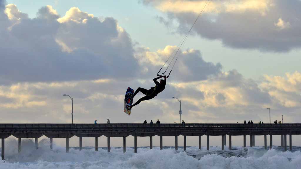 High winds fuel an impromptu kite-surfing performance for beach-goers at Ocean Beach.