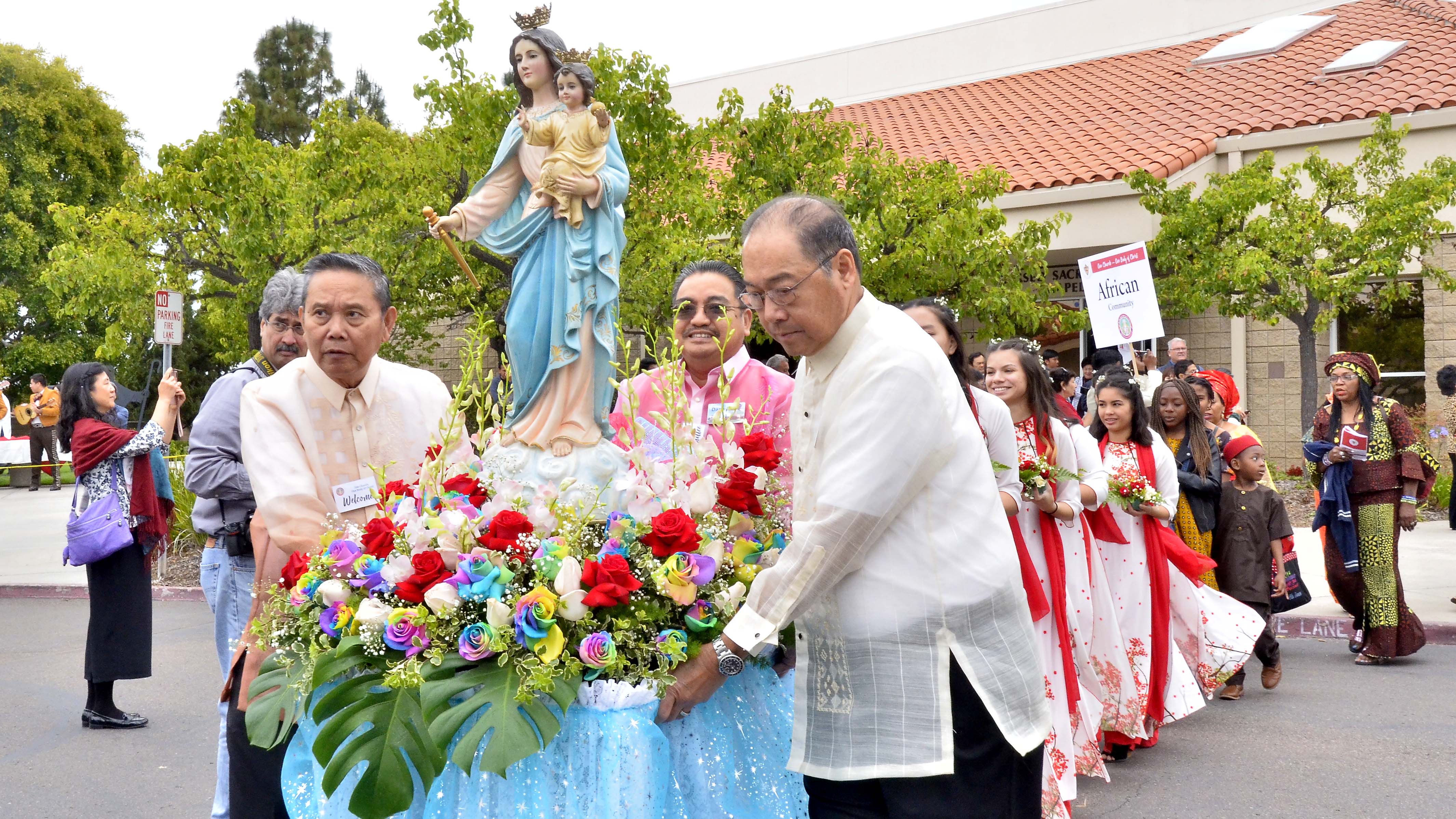 A statue of Mary is wheeled to the festival after Mass.