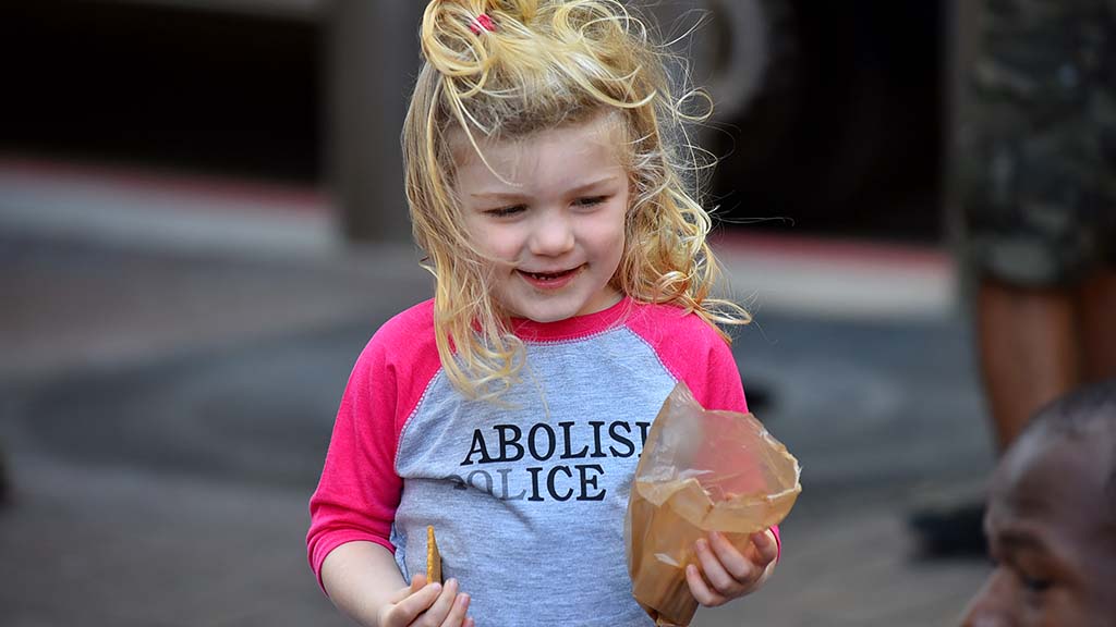 Adeline, 3, eats a snack during a protest in front of the James Carter and Judith Heed courthouse downtown.