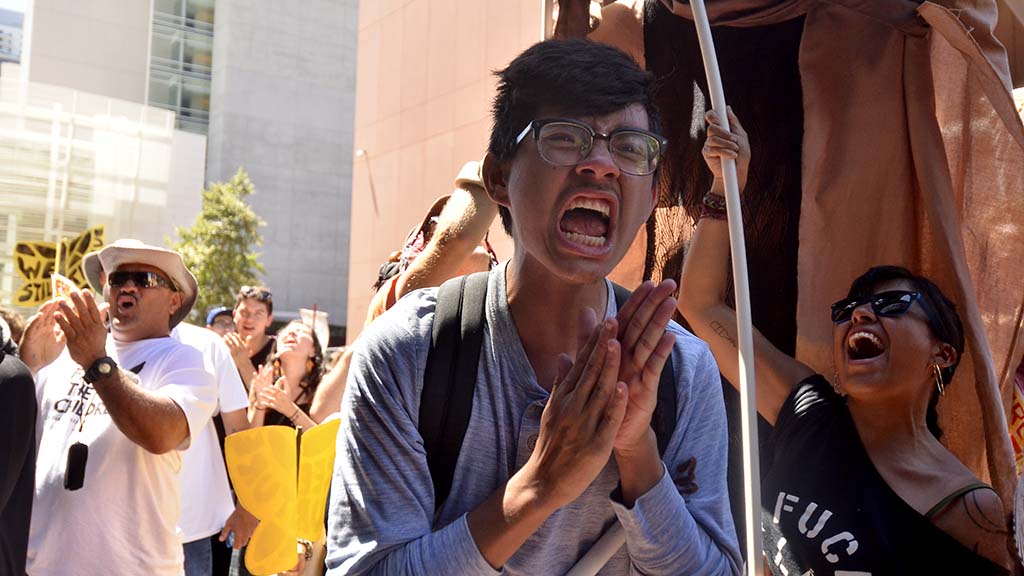 Protestors join in an ending chant in front of the courthouse.