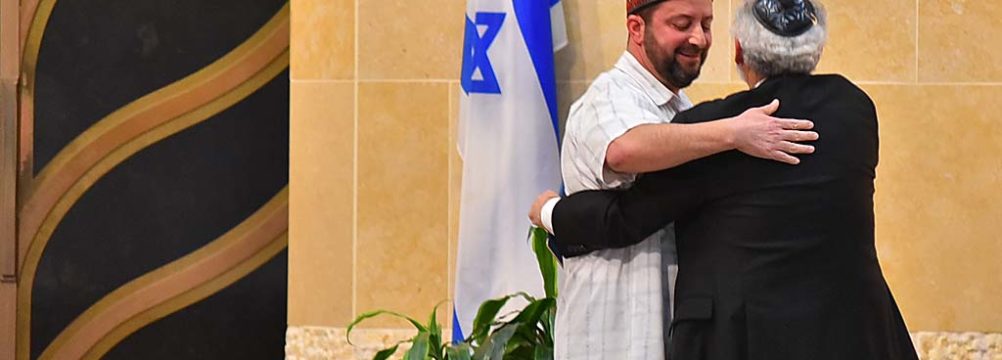 Rabbi Michael Berk of Beth Israel gives Imam Taha Hassane a hug at vigil.