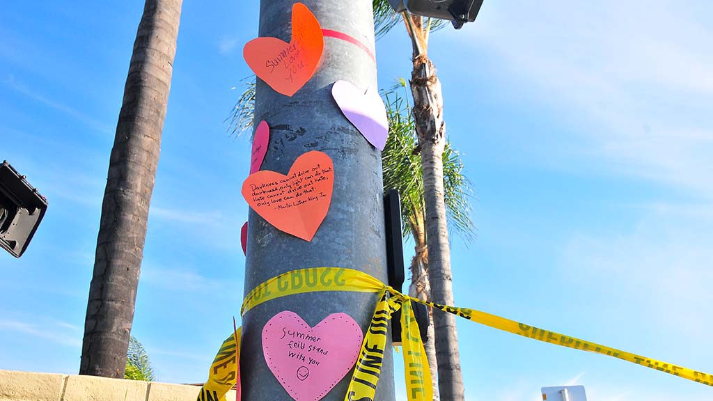 A neighborhood family taped hearts with supportive messages on a street light post across from Chabad of Poway.