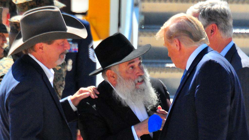 As Poway Mayor Steve Vaus looks on, Rabbi Yisroel Goldstein chats with President Trump.
