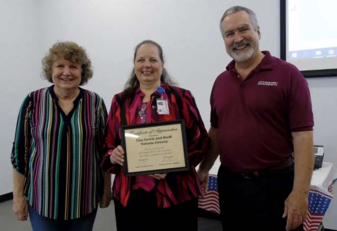 Volusia County Supervisor of Elections Lisa Lewis (center) holds a certificate of appreciation from Florida Fair Elections Coalition Director Susan Pynchon and Citizens Oversight Projects founder Ray Lutz. 